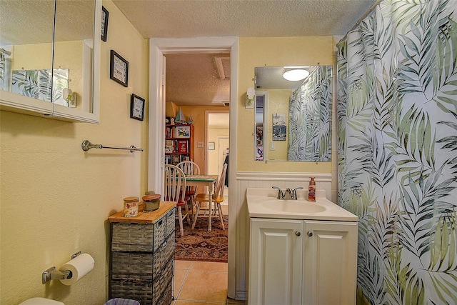 bathroom featuring vanity, tile patterned flooring, and a textured ceiling