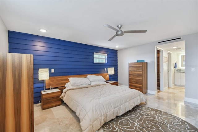 tiled bedroom featuring ceiling fan, wood walls, a spacious closet, and connected bathroom