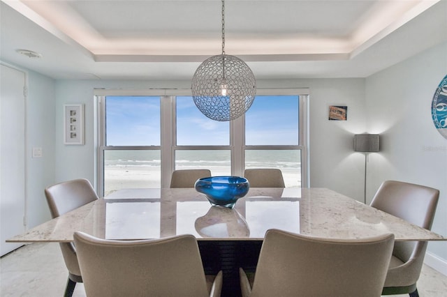 dining space with tile patterned floors, a raised ceiling, and plenty of natural light