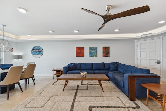 living room featuring a tray ceiling and ceiling fan