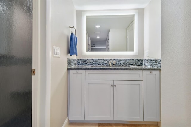 bathroom featuring tasteful backsplash, vanity, and walk in shower