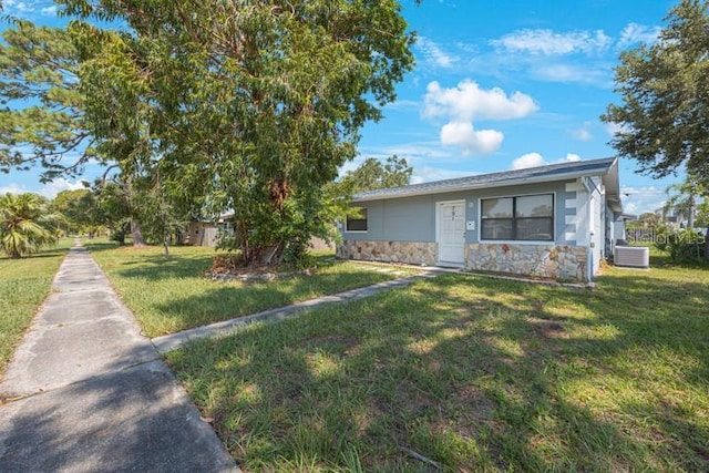 view of front of property with a front yard and central air condition unit