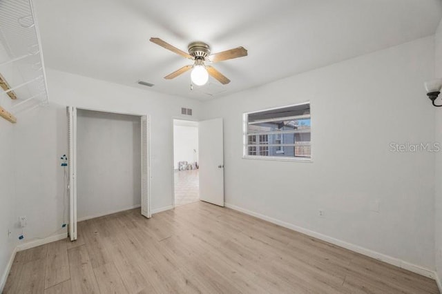 unfurnished bedroom with ceiling fan, light wood-type flooring, and a closet