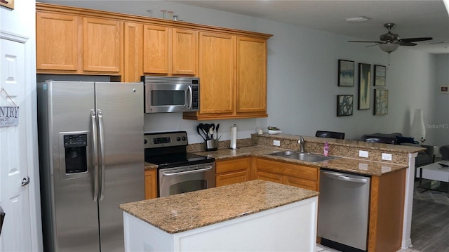 kitchen featuring kitchen peninsula, sink, ceiling fan, appliances with stainless steel finishes, and light hardwood / wood-style floors