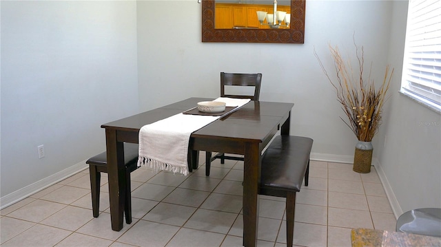 tiled dining room with a notable chandelier