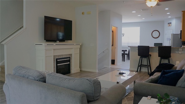 living room featuring light hardwood / wood-style flooring and ceiling fan