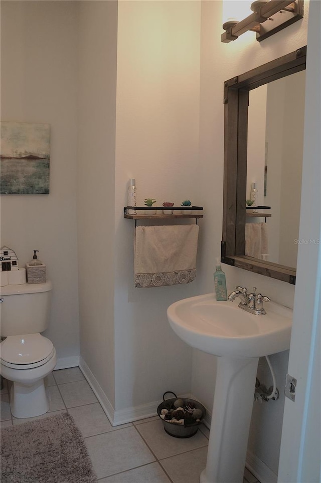 bathroom with toilet and tile patterned floors