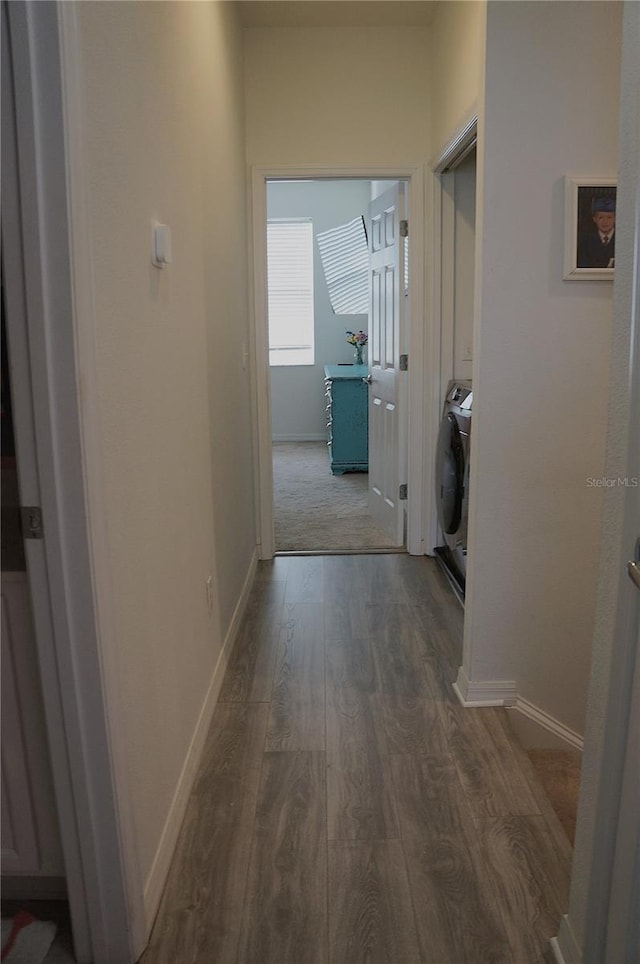 corridor with washer / dryer and wood-type flooring