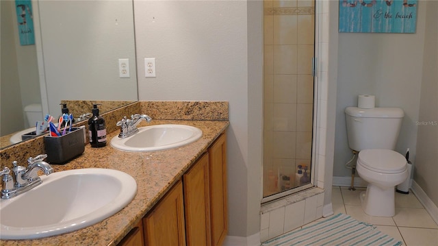 bathroom with dual bowl vanity, toilet, a shower with door, and tile patterned floors