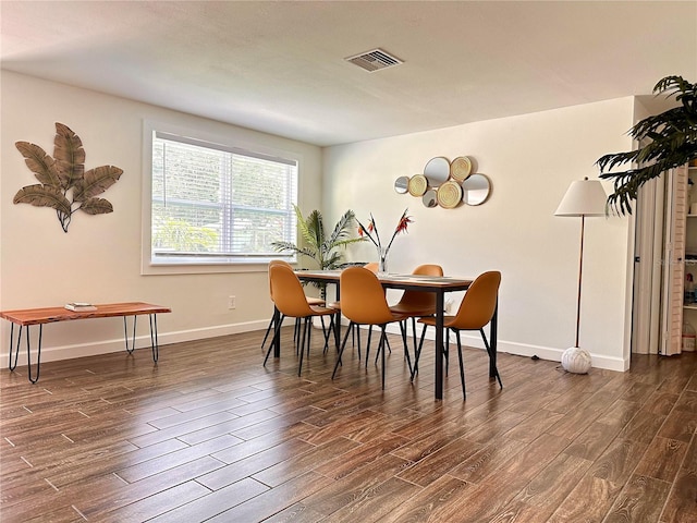 dining room with dark wood-style floors, visible vents, and baseboards