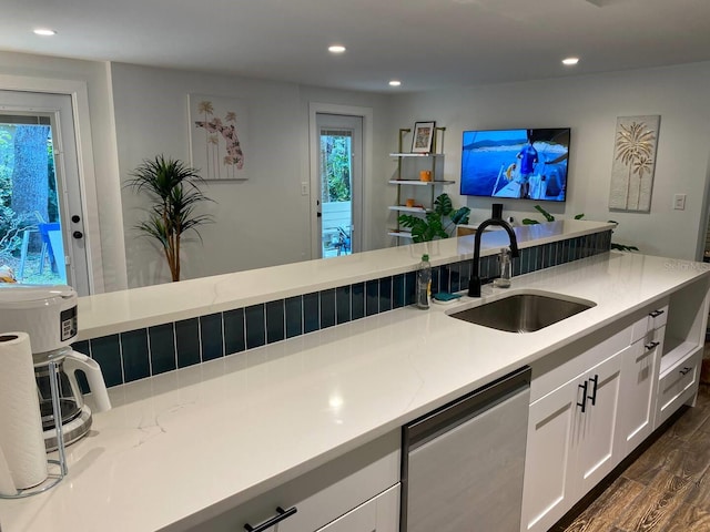 kitchen with white cabinets, a sink, dishwashing machine, dark wood finished floors, and a wealth of natural light