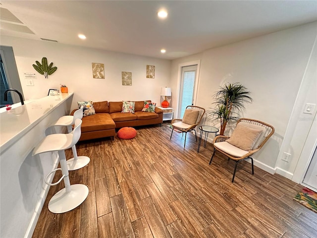 living area with visible vents, recessed lighting, wood finished floors, and baseboards