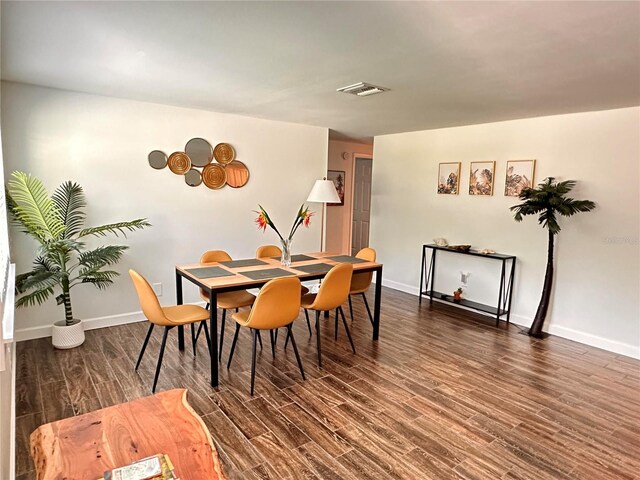 dining room featuring baseboards, visible vents, and wood finished floors