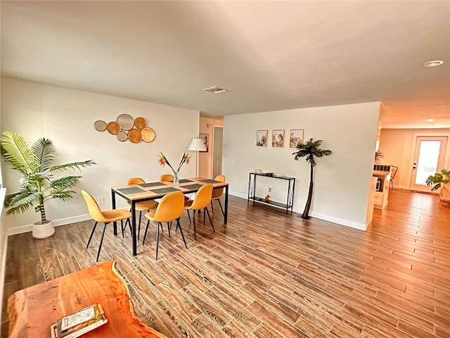 dining space with wood finished floors, visible vents, recessed lighting, and baseboards