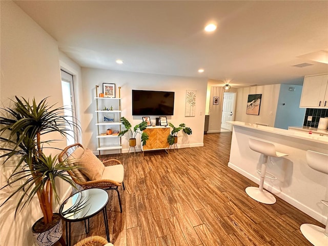 living room with wood finished floors, recessed lighting, and baseboards