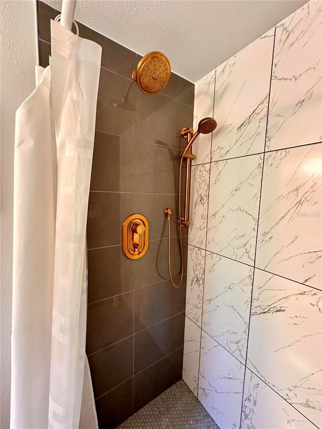 bathroom featuring a tile shower and a textured ceiling