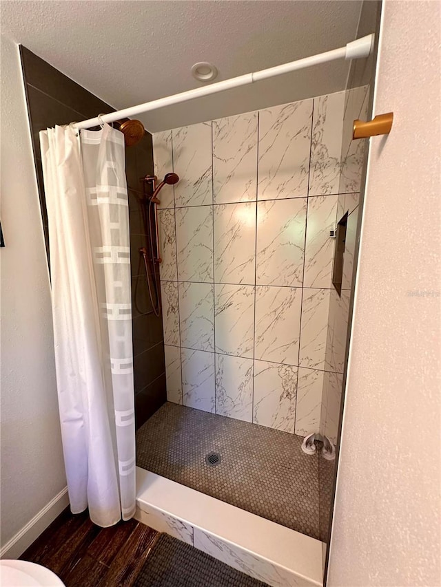 full bath with wood finished floors, a shower stall, and baseboards