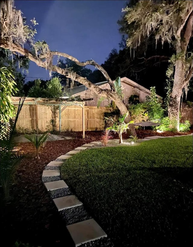 yard at twilight featuring fence