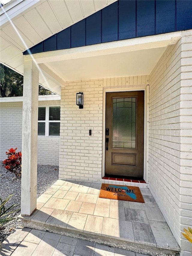 doorway to property featuring brick siding