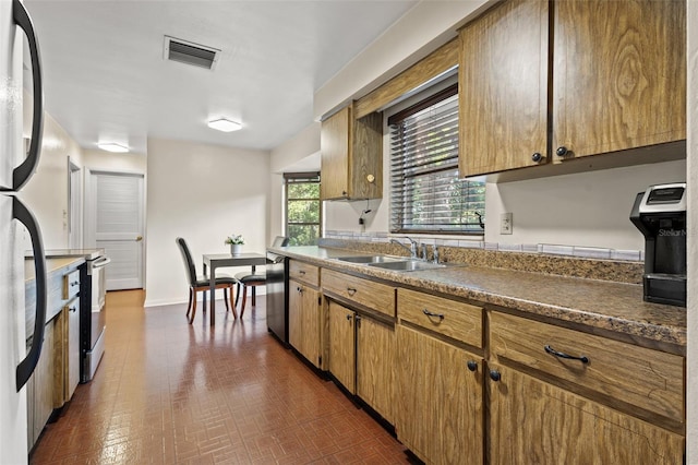 kitchen with sink, dark tile patterned flooring, and appliances with stainless steel finishes