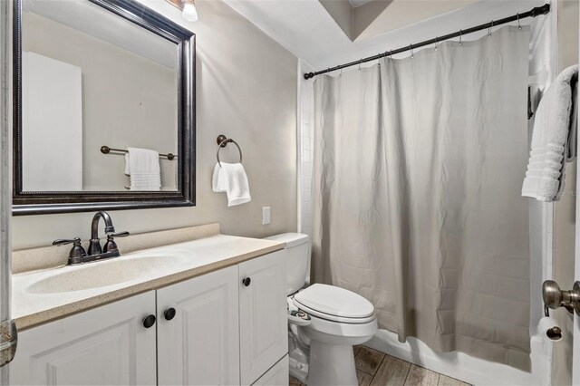 bathroom featuring toilet, hardwood / wood-style flooring, and vanity