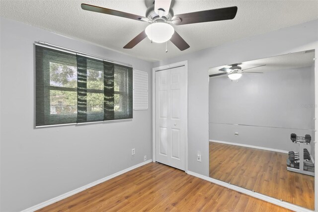 unfurnished room featuring a textured ceiling, ceiling fan, and hardwood / wood-style floors