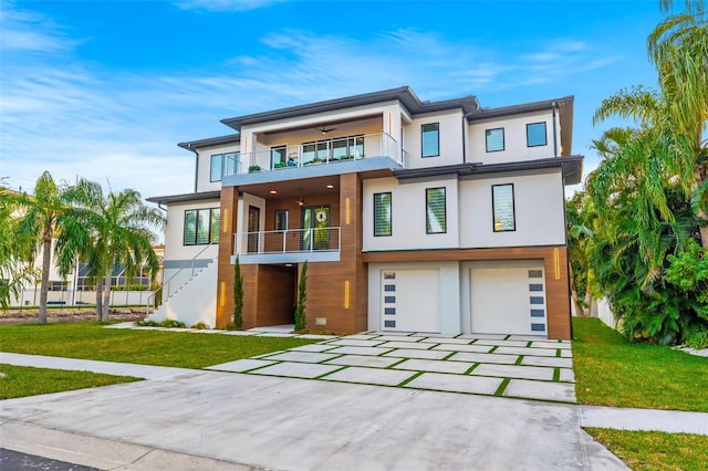 view of front of property with a balcony, a garage, and a front lawn