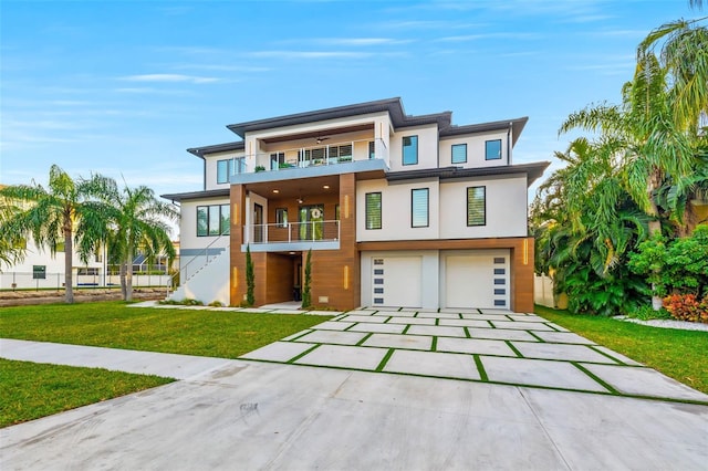 view of front of home with driveway, a garage, a balcony, a front lawn, and stucco siding