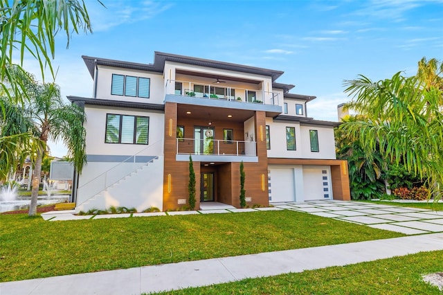 view of front of property featuring a balcony, a garage, and a front lawn