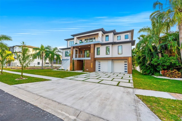 view of front of property with a balcony, a garage, and a front yard