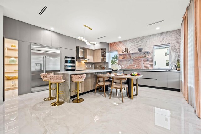 kitchen featuring open shelves, stainless steel appliances, gray cabinetry, wall chimney range hood, and modern cabinets