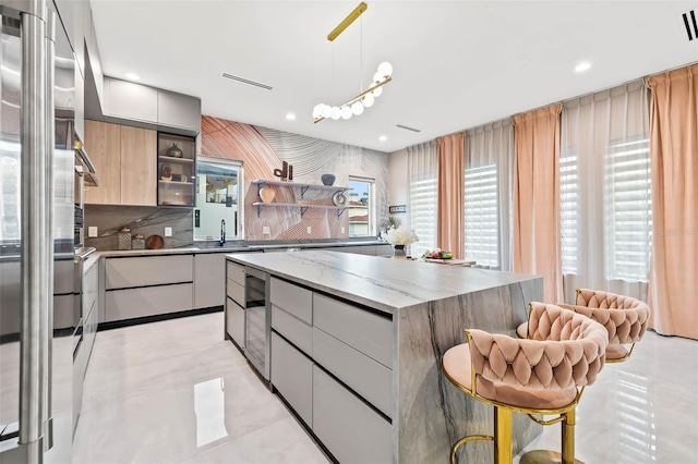 kitchen with hanging light fixtures, backsplash, a center island, open shelves, and modern cabinets