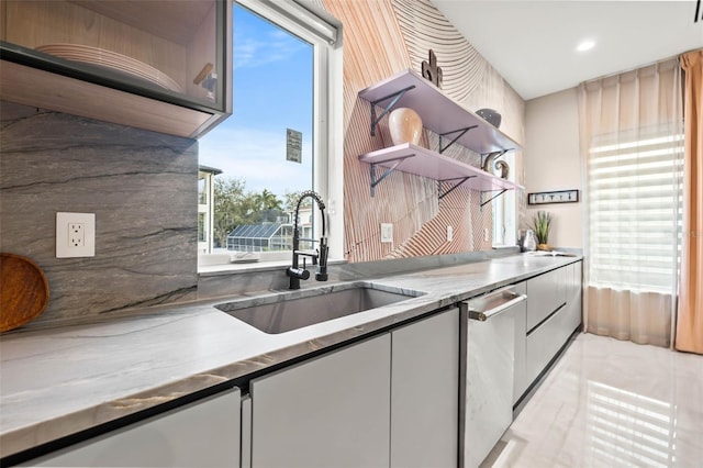 kitchen featuring stainless steel dishwasher, backsplash, light tile patterned flooring, and sink