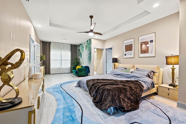 bedroom featuring ceiling fan and a raised ceiling