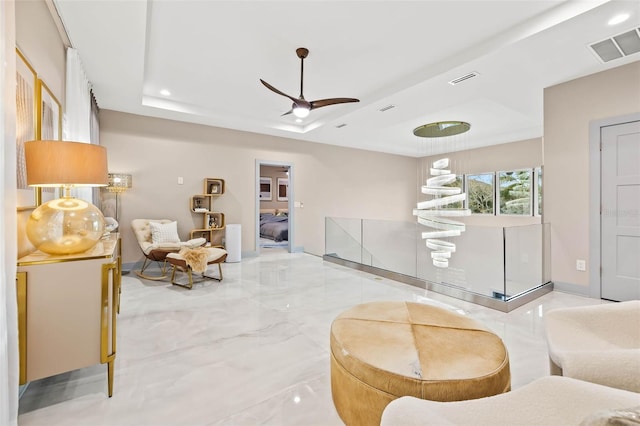 interior space featuring a tray ceiling, marble finish floor, recessed lighting, visible vents, and ceiling fan