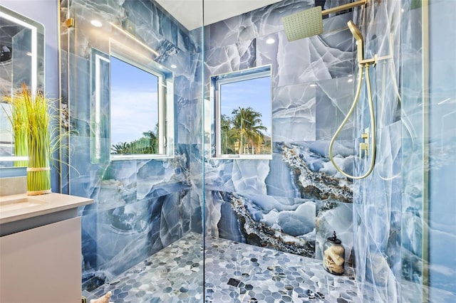 bathroom with vanity and a marble finish shower