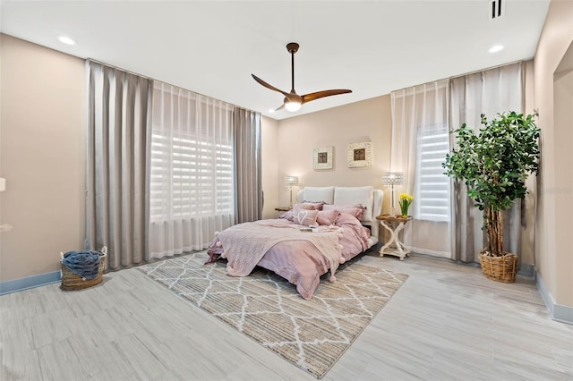 bedroom with ceiling fan and multiple windows