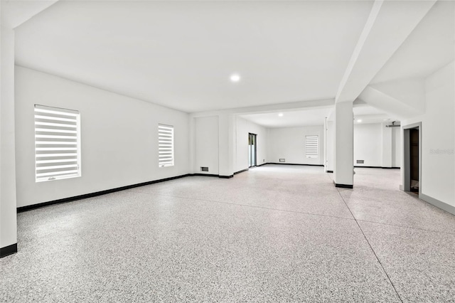 unfurnished room with recessed lighting, baseboards, and speckled floor