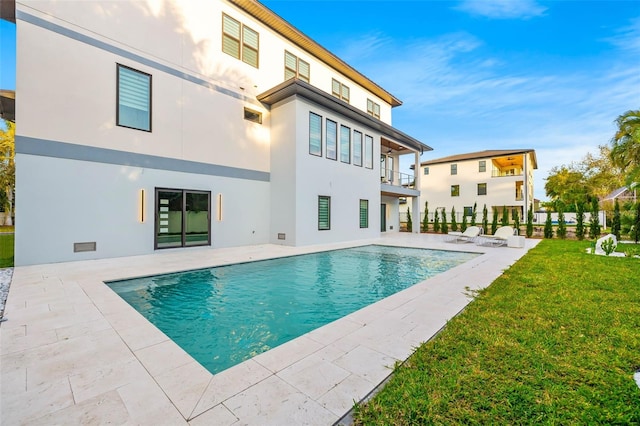 view of swimming pool featuring a fenced in pool, a patio area, and a lawn