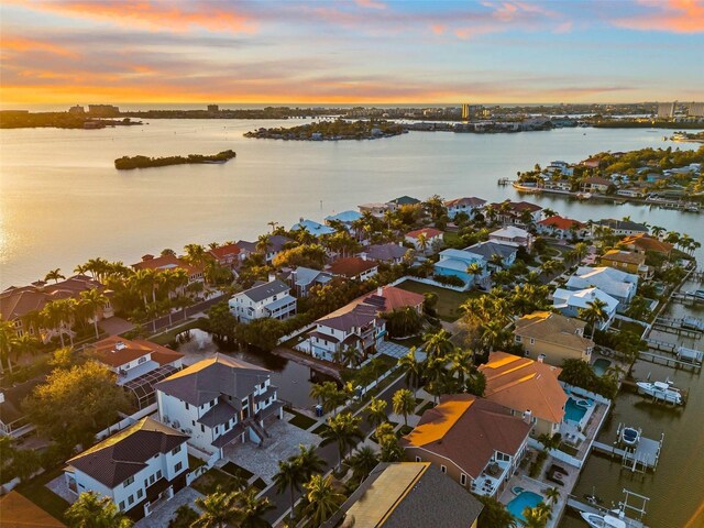 aerial view at dusk featuring a water view