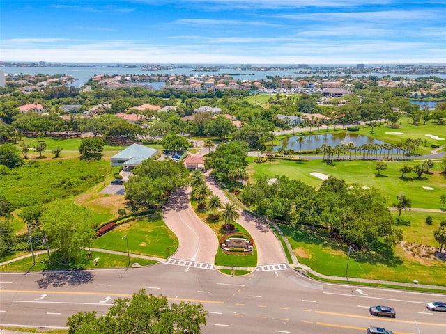 birds eye view of property with golf course view and a water view