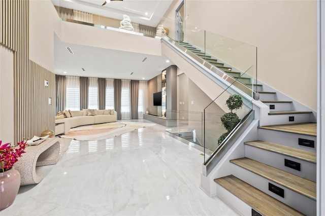 interior space featuring marble finish floor, visible vents, and a towering ceiling