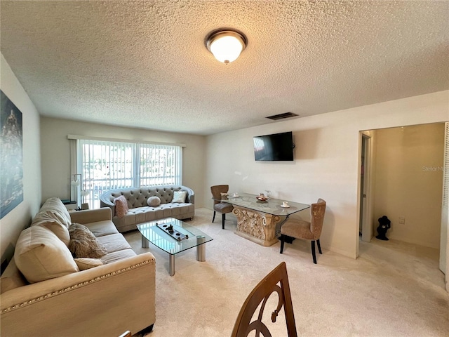 carpeted living room featuring a textured ceiling