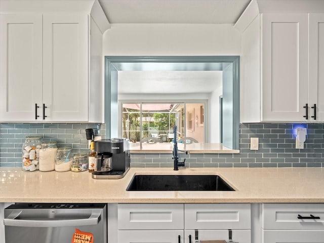 kitchen featuring sink, dishwasher, white cabinets, and tasteful backsplash