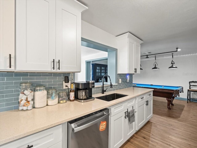 kitchen featuring sink, billiards, light hardwood / wood-style floors, stainless steel dishwasher, and tasteful backsplash