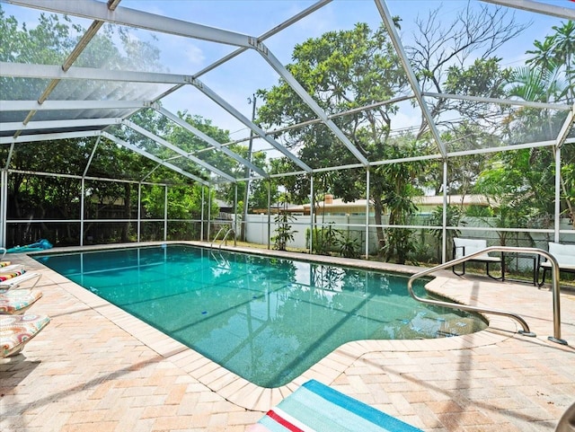 view of swimming pool with glass enclosure and a patio area