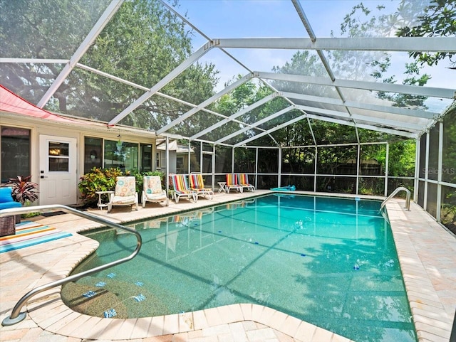 view of swimming pool with a patio area and a lanai