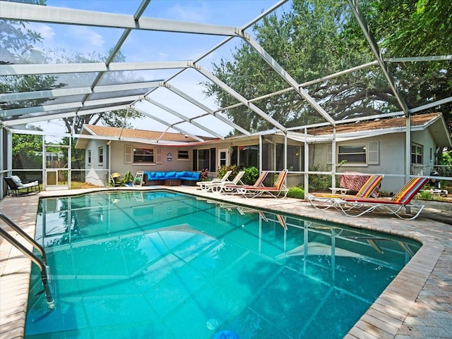 view of pool with glass enclosure and a patio area