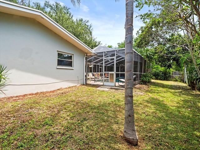 view of yard with glass enclosure and a patio