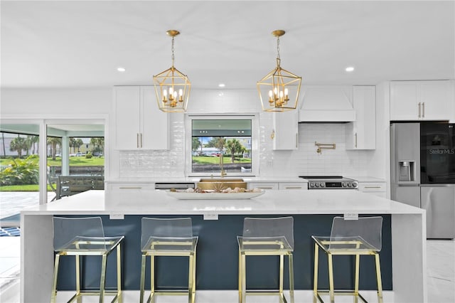 kitchen with backsplash, premium range hood, white cabinetry, and stainless steel appliances